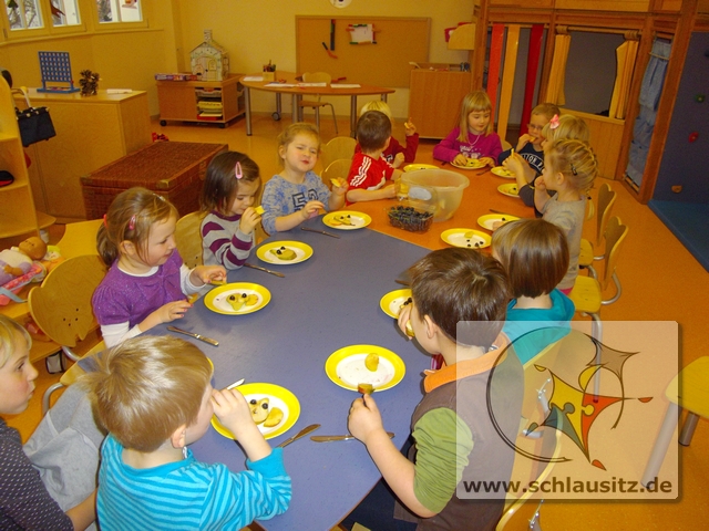 Kindergartenkinder legen aus verschiedenen Obstsorten einen Uhu